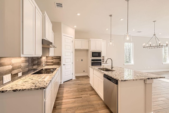 kitchen featuring stainless steel appliances, visible vents, a sink, light wood-style floors, and white cabinetry