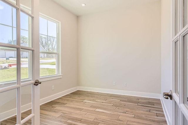 empty room with baseboards, recessed lighting, and light wood-style floors