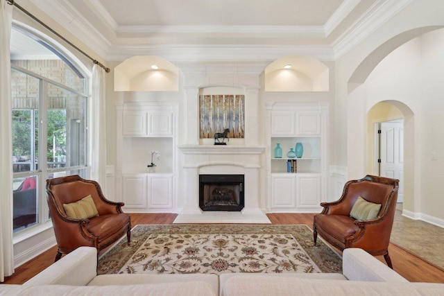 1900 Val Verde Dr, Austin, TX 78732 - living room with a fireplace with flush hearth, arched walkways, built in features, wood finished floors, and crown molding