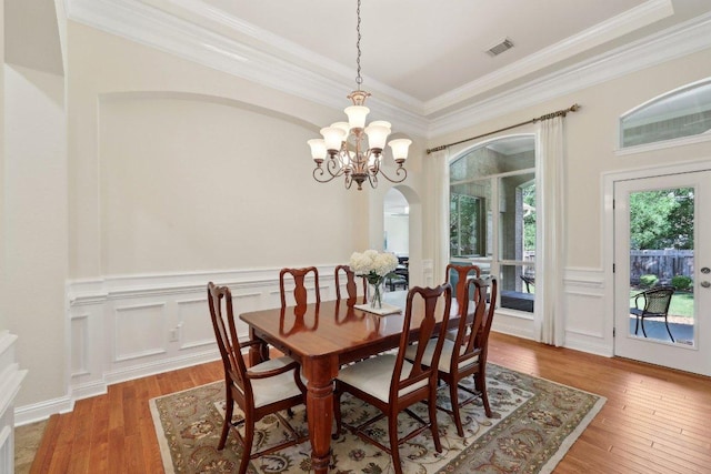 1900 Val Verde Dr, Austin, TX 78732 - dining space featuring crown molding, an inviting chandelier, a wainscoted wall, wood-type flooring, and visible vents