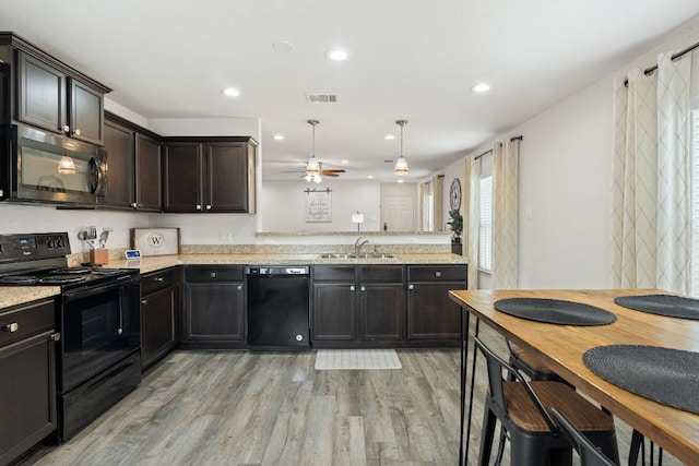 153 Proclamation Ave, Liberty Hill, TX 78642 - kitchen featuring a ceiling fan, a sink, light wood-style floors, black appliances, and a peninsula