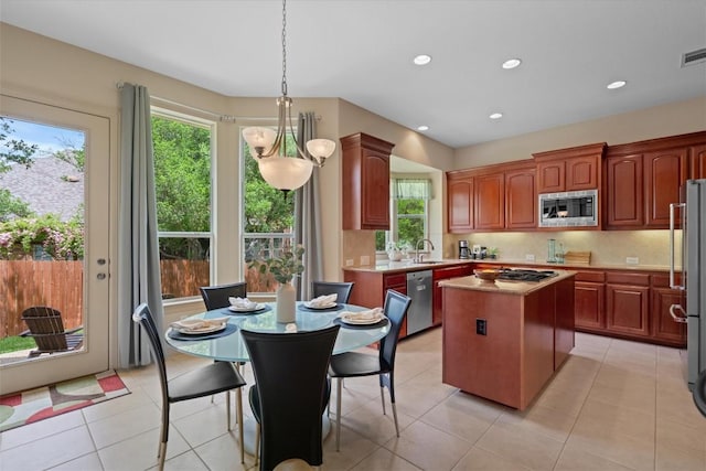 2418 Silent Brook Trl, Round Rock, TX 78665 - kitchen featuring appliances with stainless steel finishes, a center island, tasteful backsplash, healthy amount of natural light, and recessed lighting