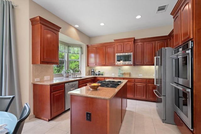 2418 Silent Brook Trl, Round Rock, TX 78665 - kitchen with stainless steel appliances, a sink, light stone counters, a center island, and light tile patterned floors