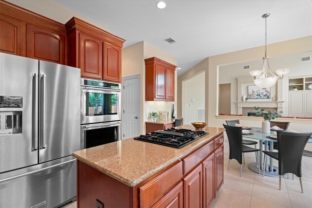2418 Silent Brook Trl, Round Rock, TX 78665 - kitchen with stainless steel appliances, a kitchen island, light stone counters, decorative light fixtures, and light tile patterned floors