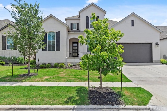 1016 Willie Ranch Way, Leander, TX 78641 - french country home with driveway, a front lawn, an attached garage, a shingled roof, and brick siding