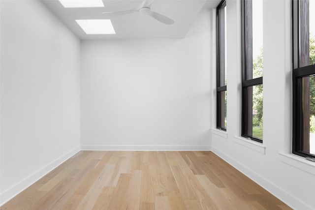 2709 Addison Ave, Austin, TX 78757 - spare room featuring baseboards, a ceiling fan, light wood finished floors, and a skylight