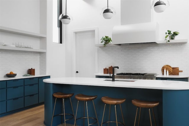 2709 Addison Ave, Austin, TX 78757 - kitchen with open shelves, modern cabinets, a kitchen bar, blue cabinetry, and backsplash