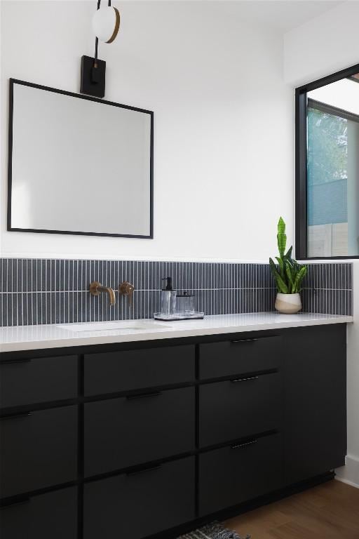 2709 Addison Ave, Austin, TX 78757 - bathroom with wood finished floors, decorative backsplash, and a sink