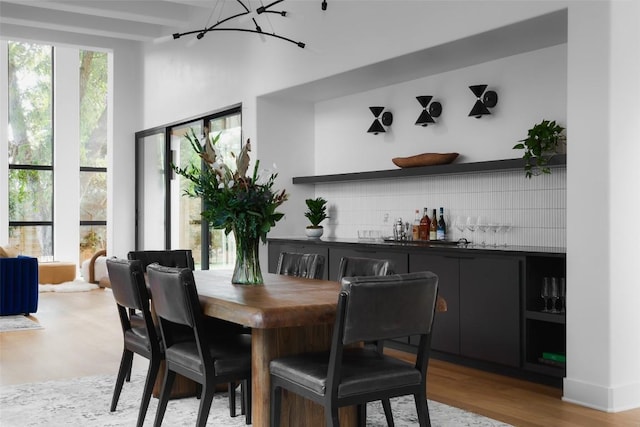 2709 Addison Ave, Austin, TX 78757 - dining area with light wood-type flooring, a dry bar, and an inviting chandelier