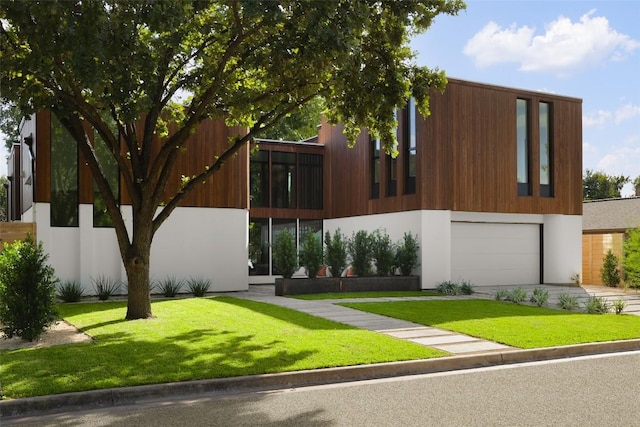 2709 Addison Ave, Austin, TX 78757 - modern home featuring concrete driveway, a front lawn, stucco siding, and a garage