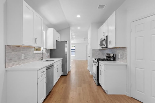 8121 Almondsbury Ln, Austin, TX 78748 - kitchen with stainless steel appliances, recessed lighting, light countertops, light wood-style flooring, and white cabinetry