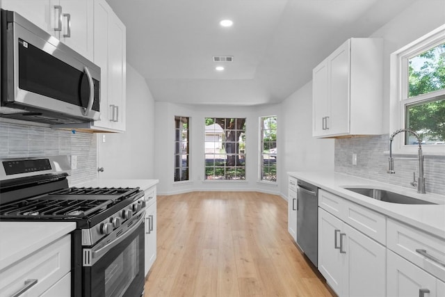 8121 Almondsbury Ln, Austin, TX 78748 - kitchen featuring stainless steel appliances, a sink, light countertops, light wood-style flooring, and white cabinetry