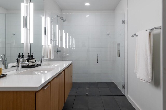 bathroom with a shower stall, tile patterned flooring, a sink, and double vanity