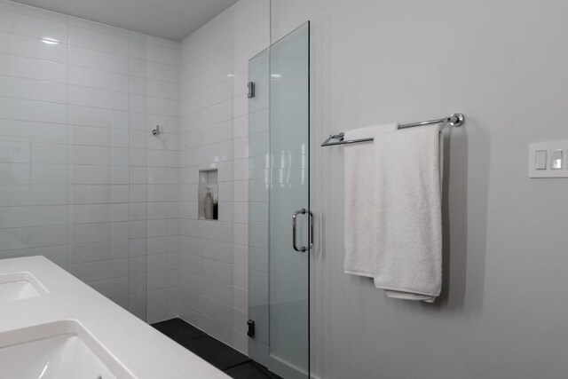 full bath featuring a stall shower and double sink