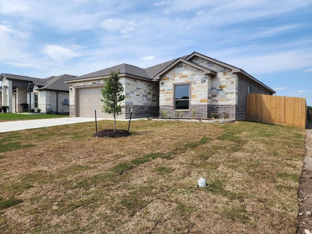 view of front of home with stone siding, concrete driveway, fence, a garage, and a front yard