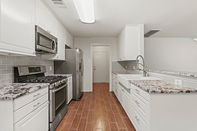 400 W Tudor House Rd, Pflugerville, TX 78660 - kitchen featuring appliances with stainless steel finishes, a sink, white cabinets, and backsplash
