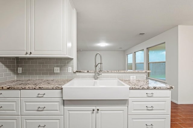 400 W Tudor House Rd, Pflugerville, TX 78660 - kitchen with a sink, tasteful backsplash, white cabinetry, dark wood finished floors, and light stone counters