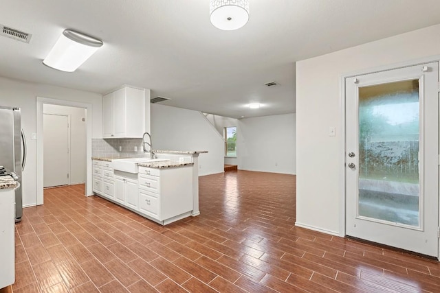400 W Tudor House Rd, Pflugerville, TX 78660 - kitchen with a sink, white cabinetry, backsplash, baseboards, and light stone countertops