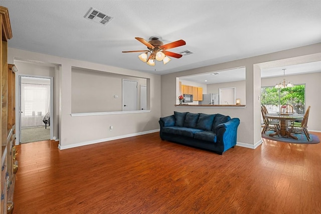 4302 Kings Canyon Dr, Taylor, TX 76574 - living area with wood finished floors, visible vents, baseboards, and ceiling fan with notable chandelier