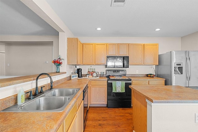 4302 Kings Canyon Dr, Taylor, TX 76574 - kitchen with a sink, black appliances, light brown cabinetry, visible vents, and recessed lighting