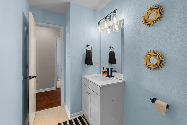 4302 Kings Canyon Dr, Taylor, TX 76574 - bathroom with baseboards, wood finished floors, and vanity