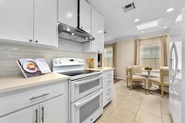 7313 Grover Ave, Austin, TX 78757 - kitchen featuring double oven range, ventilation hood, light countertops, white cabinetry, and recessed lighting