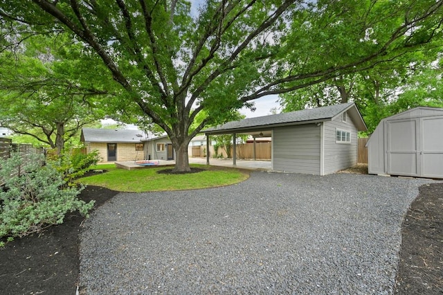 back of property featuring fence, an outdoor structure, and a storage shed