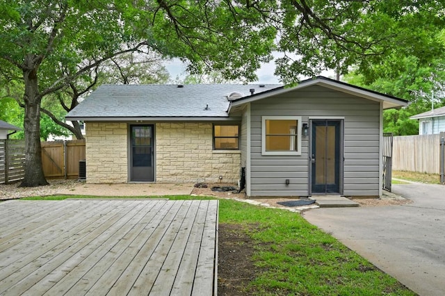 7313 Grover Ave, Austin, TX 78757 - rear view of property with a wooden deck, stone siding, and roof with shingles