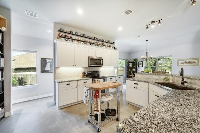 19908 Victoria Chase Rd, Lago Vista, TX 78645 - kitchen featuring stainless steel appliances, backsplash, white cabinetry, a chandelier, and light stone counters