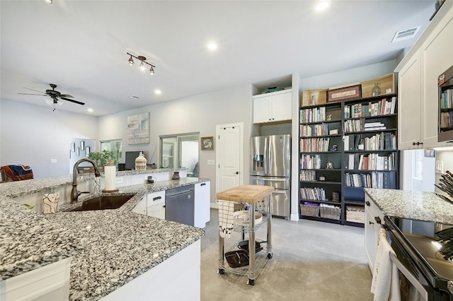 19908 Victoria Chase Rd, Lago Vista, TX 78645 - kitchen with appliances with stainless steel finishes, concrete flooring, white cabinets, and recessed lighting