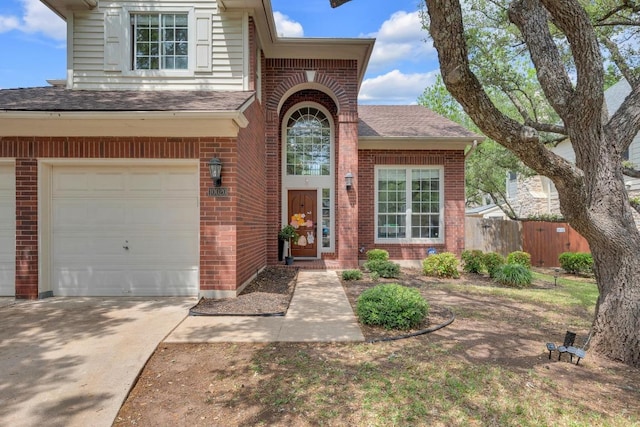 10020 Lachlan Dr, Austin, TX 78717 - doorway to property with brick siding, an attached garage, roof with shingles, and fence