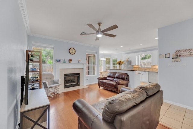 10020 Lachlan Dr, Austin, TX 78717 - living room featuring a tiled fireplace, ornamental molding, a ceiling fan, and a healthy amount of sunlight