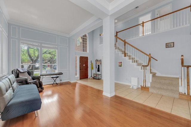 10020 Lachlan Dr, Austin, TX 78717 - living room featuring crown molding, a decorative wall, a towering ceiling, and stairs