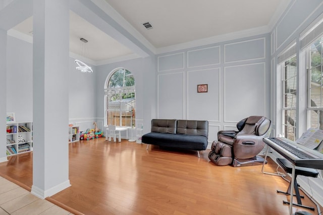 10020 Lachlan Dr, Austin, TX 78717 - living area with a decorative wall, wood finished floors, a chandelier, ornamental molding, and visible vents