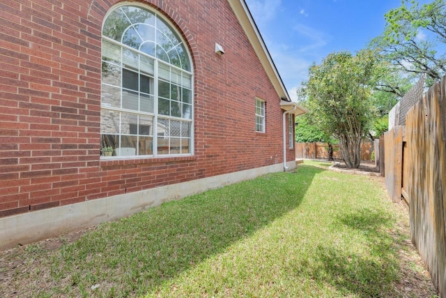 10020 Lachlan Dr, Austin, TX 78717 - view of home's exterior featuring brick siding, a lawn, and a fenced backyard