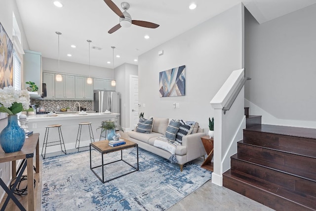 living area with a ceiling fan, recessed lighting, stairway, and finished concrete floors