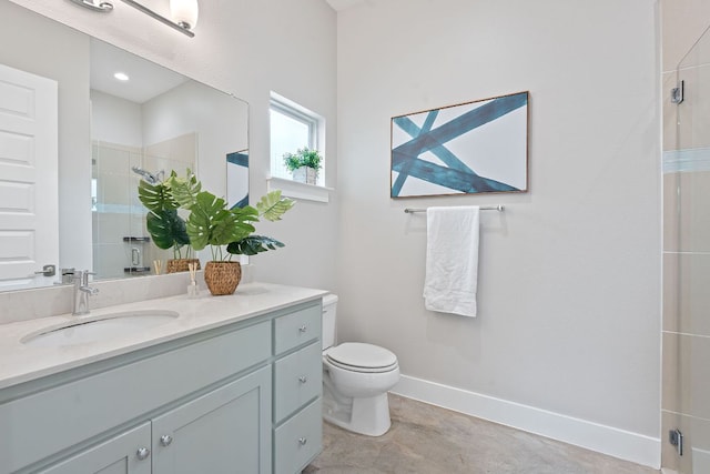full bathroom featuring a shower stall, vanity, baseboards, and toilet