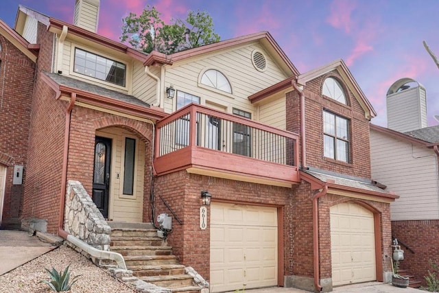 6610 Mesa Hollow Dr, Austin, TX 78750 - view of property featuring a balcony, a garage, brick siding, a chimney, and driveway