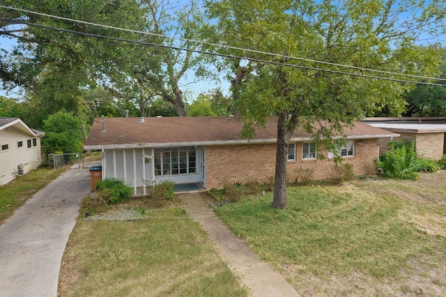 ranch-style house featuring a front lawn and brick siding