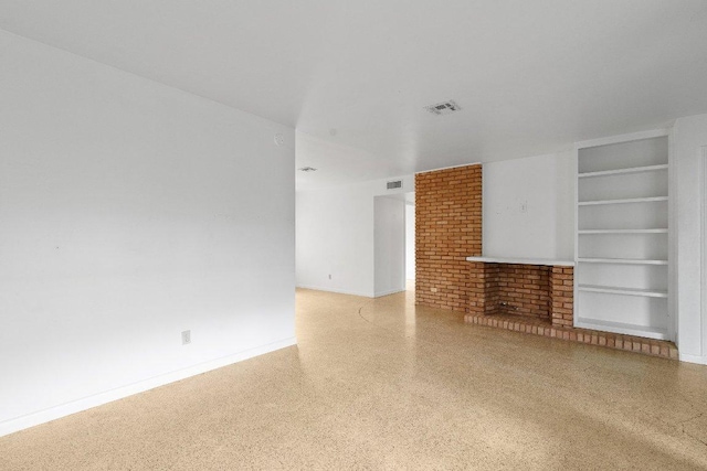 unfurnished living room with speckled floor, visible vents, built in features, and baseboards