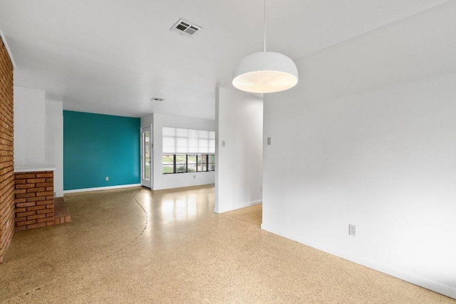 unfurnished living room featuring speckled floor, baseboards, and visible vents