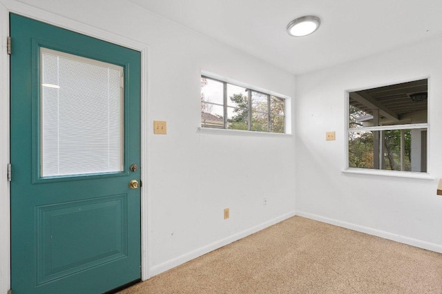 doorway with carpet floors and baseboards