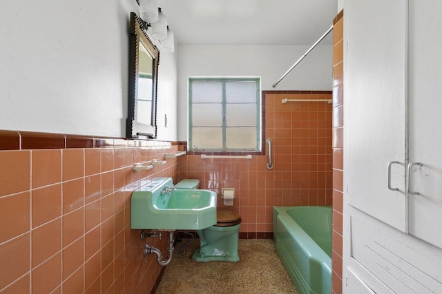 full bathroom with toilet, a sink, tile walls, wainscoting, and shower / bathing tub combination