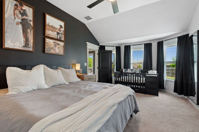 carpeted bedroom featuring lofted ceiling, a ceiling fan, and visible vents