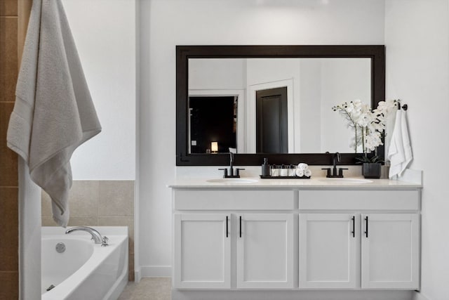 bathroom featuring a garden tub, baseboards, a sink, and double vanity