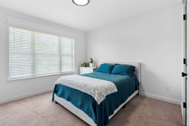 bedroom with baseboards and carpet