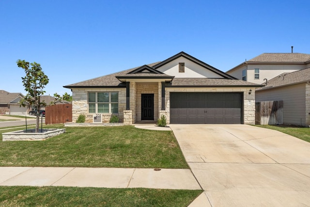 prairie-style home with a front lawn, fence, stone siding, and a garage