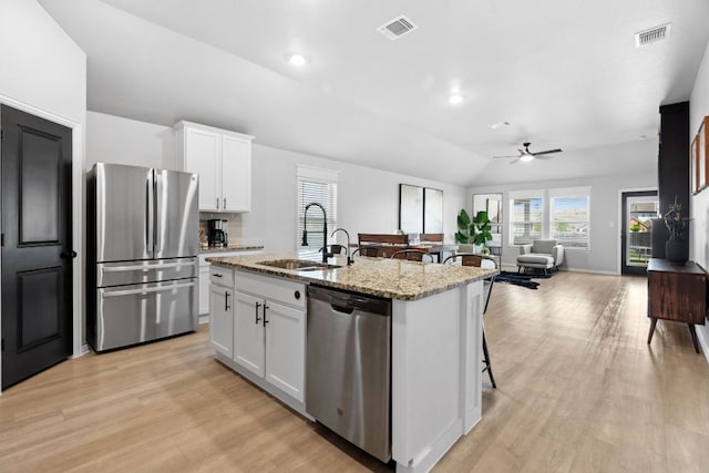 kitchen featuring stainless steel appliances, light wood-style flooring, a sink, visible vents, and a ceiling fan