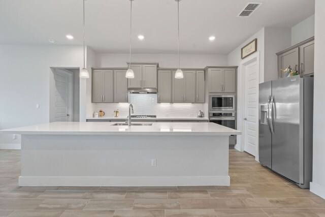 kitchen featuring stainless steel appliances, light wood-style flooring, a sink, visible vents, and gray cabinets