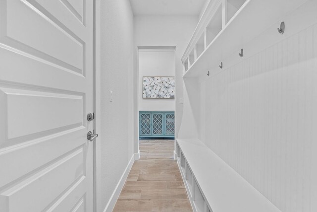 mudroom with light wood-style flooring and baseboards